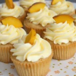 Honey peach cream cheese cupcakes on a floral patterned plate.